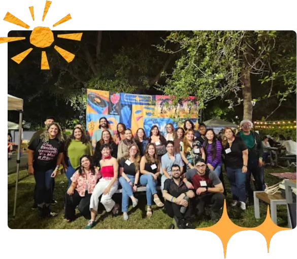 Panas gathered outdoors in front of hand-painted Pana Mia banners